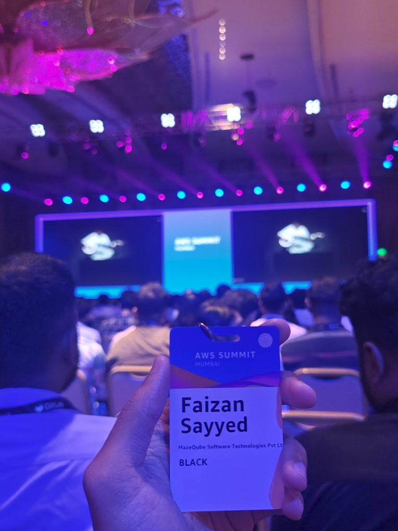 AWS Summit delegate badge held up in front of the stage
